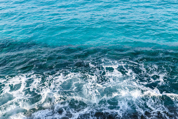 Fototapeta na wymiar Deep blue water with shore foam