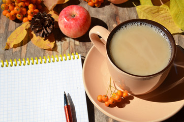 Workspace with golden leaves, notebook, coffee cup. Stylish office desk. Autumn or Winter concept. Flat lay, top view.