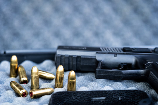 Close up view of bullets and handgun. Shallow depth of field. Focus on a pistol.