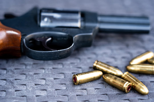 Close up view of bullets and handgun. Shallow depth of field. Revolver out of focus.