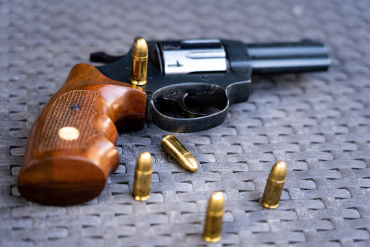 Close up view of bullets and handgun. Shallow depth of field. Revolver in a focus.