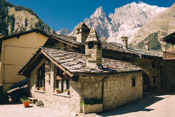 Beautiful old house in Courmayeur, Italy, over panoramic view of Mont Blanc. - obrazy, fototapety, plakaty