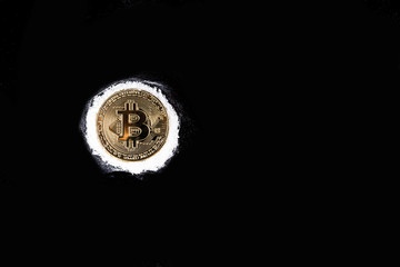 Gold bitcoin sprinkled with cocaine on a black table