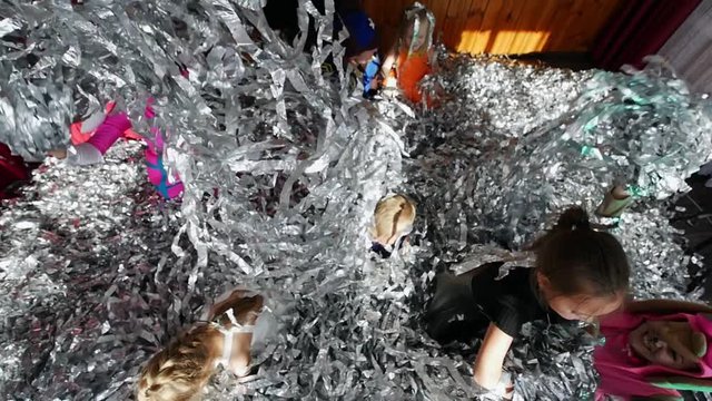 Children's party, where children and animators play with shiny ribbons. Show animators.