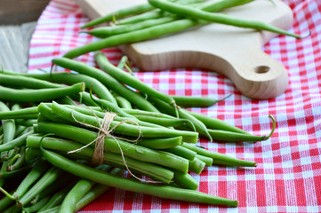 Healthy and benefits with bush beans.
Green beans tied with rope  on wooden background.
