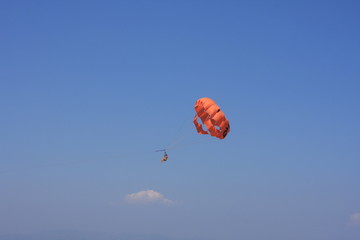 Parasailing water amusement. Flying on a parachute behind a boat on a summer holiday by the sea
