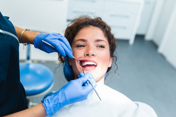Beautiful young woman having dental treatment at dentist's office.