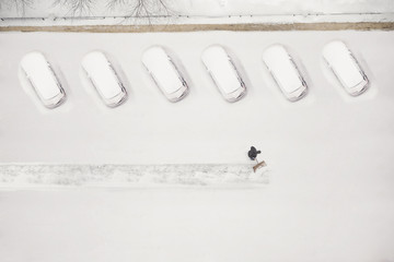 janitor cleans the snow-covered parking space during the snow season. Winter time.