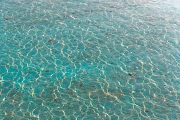coins at the bottom of a lake with blue water.