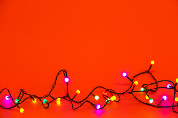 Christmas lights over red background. Colorful border with empty copy space for text.