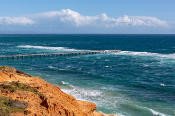 The Port Noarlunga Jetty in rough seas from the northern cliff face in South Australia on the 6th September 2018
