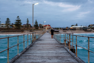Naklejka premium A fisherman on the Port Noarlunga Jetty looking back towards the shore at Port Noarlunga South Australia on 12th September 2018