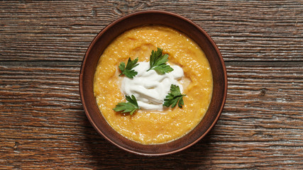 pumpkin soup in bowl on wooden table