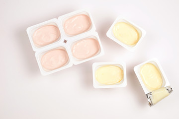 Plastic cup with tasty yogurt isolated on white. Top view. Space for text or design.