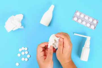 Medicines for flu, illness, cold, cough against a blue table with tablets. Top view, copy space, flat lay.
