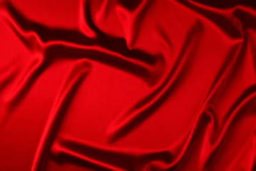 Red silk or satin luxury fabric texture can use as abstract background. Top view.