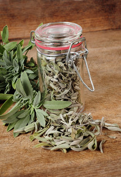 glass with dried sage and fresh sage over wooden background