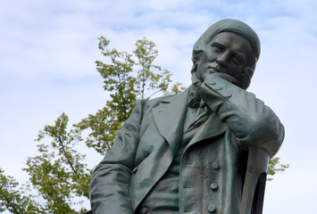 Robert-Schumann-Denkmal mit Baum und blauem Himmel im Hintergrund