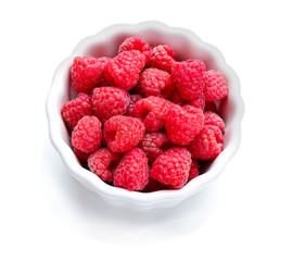 Bowl with ripe raspberries on white background