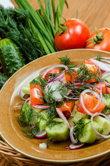 Obraz na płótnie Canvas Fresh salad with tomatoes, onion and cucumbers.