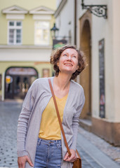 A tourist woman is walking around Prague on a sunny day.