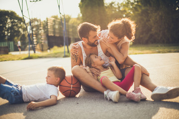 Fototapeta premium Happy family together at basketball playground.