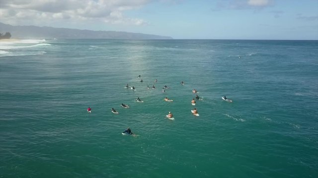 Surfers waiting in line up for next set of waves. Nice sunny day aerial drone
