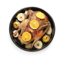 Tasty roasted duck with oranges and apples for Christmas dinner on white background
