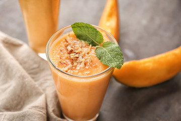 Glass of tasty melon smoothie on table, closeup