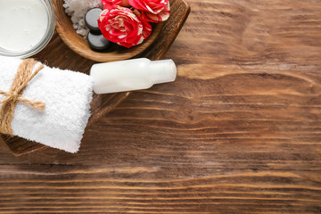 Beautiful spa composition with sea salt and cream on wooden background