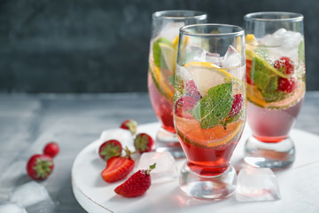 Glasses of fresh strawberry lemonade on wooden board