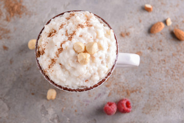 Cup with delicious rice pudding and hazelnuts on light table