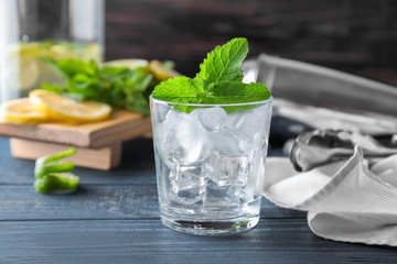 Glass with ice for mojito cocktail on wooden table