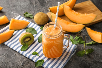 Mason jar of tasty melon smoothie on table