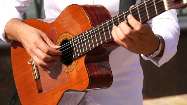 A guitarist plays on a street. Slow motion