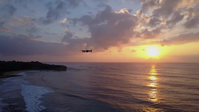 Shot of flying drone DJI MAVIC in the air. Hawaiian sunrise ocean background