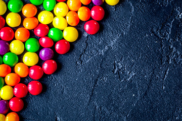sweets and sugar candies on dark background top view