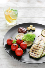 Tasty grilled vegetables with sauces on plate