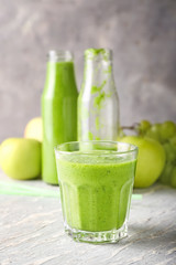 Glass of tasty green smoothie on wooden table