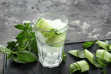 Glass of cucumber infused water with ice on table