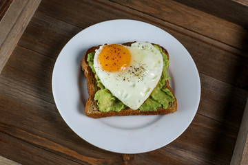 Toast with avocado and egg in heart shape