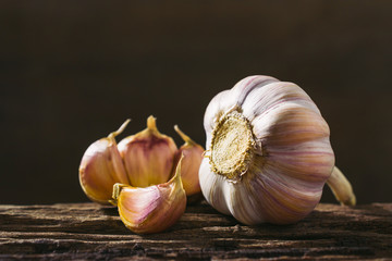 Closeup garlic on wooden texture on for cooking on dark background