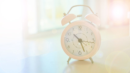 Clock Classic Vintage Retro Color Tone on Wood Table with Sun Light