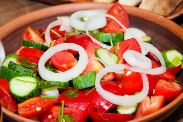 Salad of tomatoes, cucumbers, peppers, onions and greens dressed with olive, sunflower or corn oil