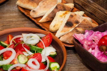 Salad of tomato, cucumber, onion, pepper, sauerkraut with buryak, khachapuri. A dish of Georgian cuisine