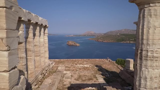 Drone flying through Greek temple of Poseidon in morning light. Aerial view