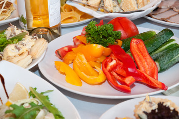 Sliced pepper tomato cucumber on a table in a plate, wine. New Year, festive table