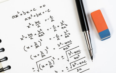 Handwriting of mathematics quadratic equation formula on examination, practice, quiz or test in...