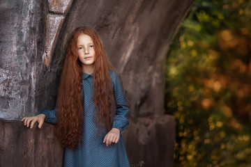 girl standing under old stone bridge