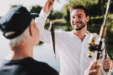 Old Father with Bearded Son Fishing on River.